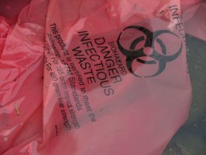 An orange bag with a biohazard symbol printed on it